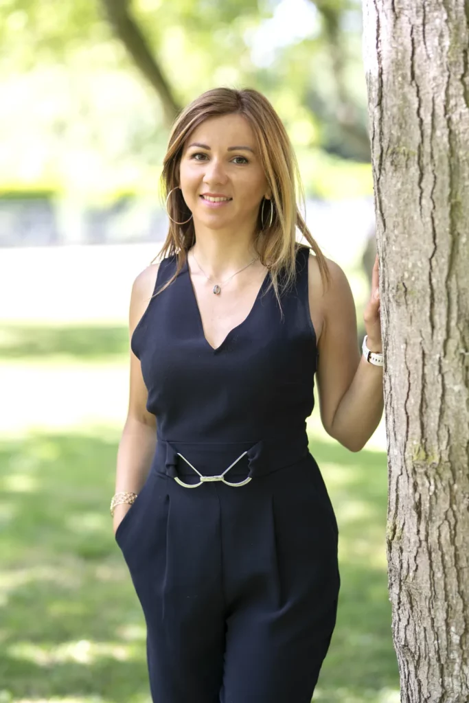 Portrait de Marie-Laure Madeleine en combinaison marine, adossée à un arbre